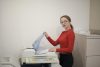 Female in red long sleeve shirt scanning in documents to a scanner